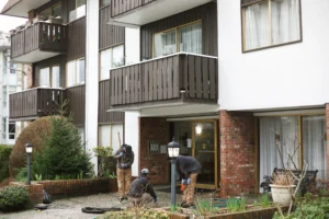 Front of Vancouver apartment building with installers working commercial concrete repair