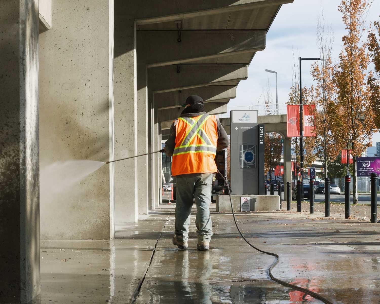 crewman washing concrete with hose