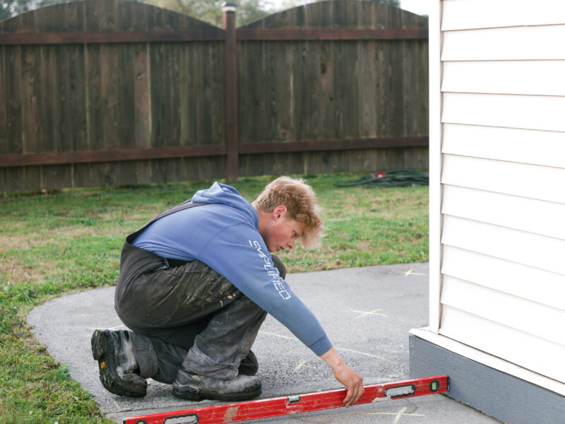 installer measuring sidewalk levels