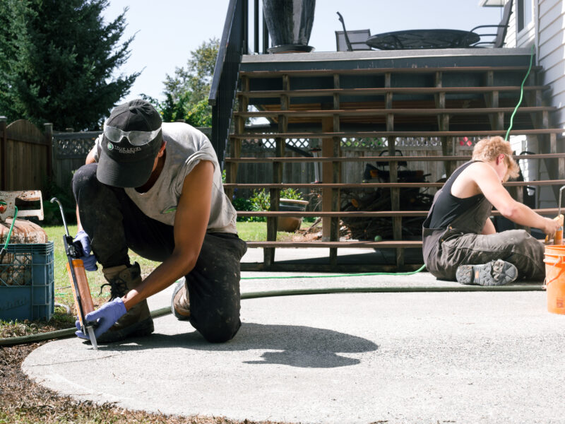 installer doing crack repair on a patio